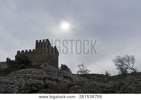 Genoese Fortress In Sudak, Crimea. Consular Castle And A Lonely Tree Against A Cloudy Sky. Early Apr