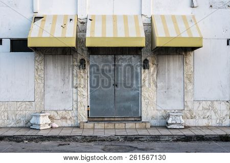 Facade And Weathered Front Door Of Abandoned Hotel Building