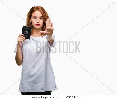 Young beautiful woman holding passport of united states of america over isolated background with open hand doing stop sign with serious and confident expression, defense gesture