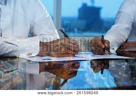 Businessmen Hands Signing Documents On Riyadh Skyline City Scape Background Multi Exposure