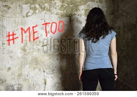Young Woman Standing At The Grunge Wall With Sprayed Sign #me Too. Sexual Harassment Concept
