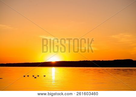 Six Origami In The Form Of Boats Sail By The Lake At Sunset In The Evening.  Paper Boats Are Driftin