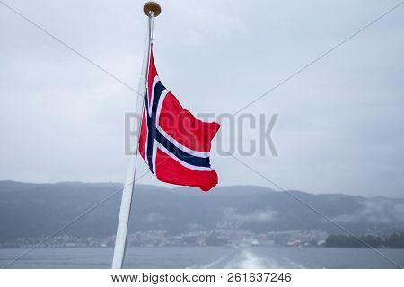 A Beautiful Closeup Of A Norway National Flag On The Pole On Ferry. Wind Fluttering The Flag In Fjor