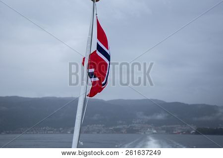 A Beautiful Closeup Of A Norway National Flag On The Pole On Ferry. Wind Fluttering The Flag In Fjor