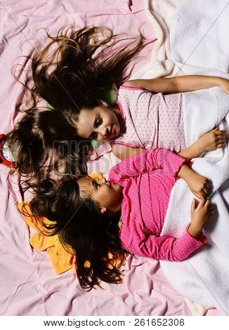 Schoolgirls In Pink Pajamas Wallow On Colorful Pillows, Top View