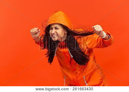 The Young Girl Posing At Studio In Autumn Jacket Isolated On Red. Human Negative Emotions. Concept O