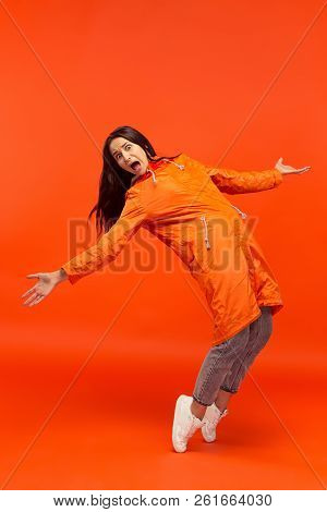 The Young Girl Posing At Studio In Autumn Jacket Isolated On Red. Human Negative Emotions. Concept O