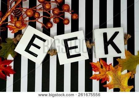 Eek Halloween Phrase Letters On Fun Black And White Stripe Background.  Maple Leaves And Orange Glit