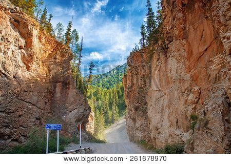 Road Through Narrow Passage In The Rocks. Red Gate On The Chibit River.