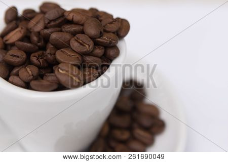 Top View Ceramic Cup With Brown Coffee Seeds And Beans Isolated On White Background