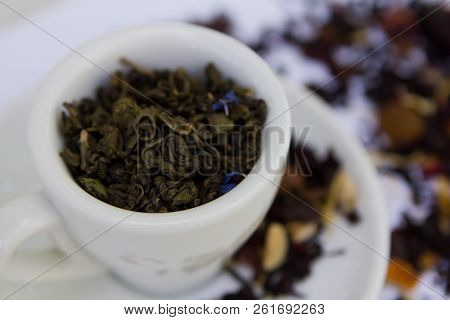 Green Tea Petals And Herbs In White Ceramic Cup Top View