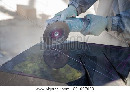 The Work Of The Stone Sculptor Gabbro Granite. Stone Cutting By Grinding Machine. Dusty Work