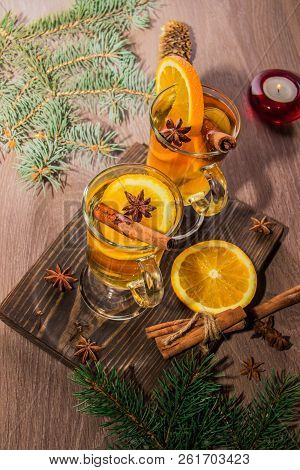 Two Glasses With Delicious Fragrant Tea Of Mulled Wine With Orange And Spices On A Wooden Board With