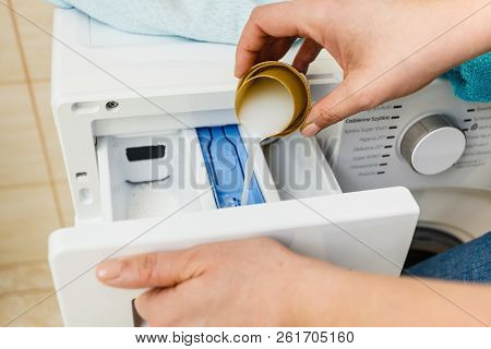 Liquid Powder Detergent And Measuring Cup Pouring Into Machine. Household Duties, Clothes Laundry Ob