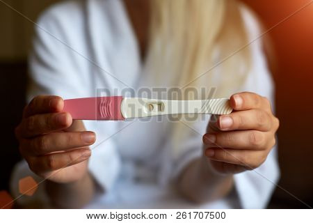 Close Up Of Woman Hand Holding A Positive Home Pregnancy Test