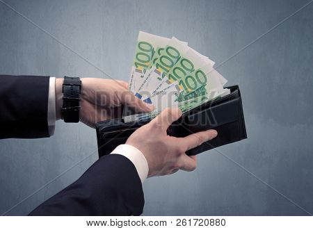Businessman's hand in suit takes out eruo from his wallet