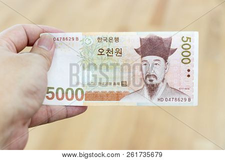 Business Man Hold South Korea Banknote 5000 Korean Won On Wood Background