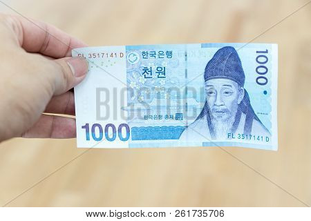 Business Man Hold South Korea Banknote 1000 Korean Won On Wood Background