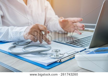 Medicine Doctor Hand Explaining For Patient At Consulting Room, Working On Laptop Computer On Desk I