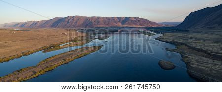 Sun Lights Up The Ridge Behind The Waterfront Town Of Beverly Washington As The Columbia River Flows