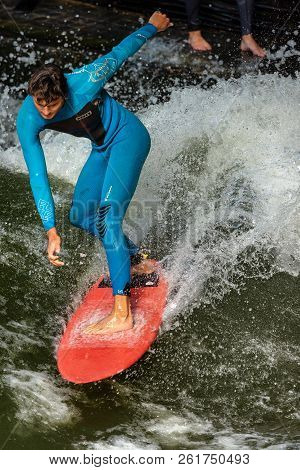 Munich, Germany - Sept 8, 2018: Man Surfing In The Waves Of The Eisbach River In Munich. It Forms A 