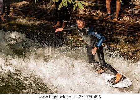 Munich, Germany - Sept 8, 2018: A Man Surfing In The Waves Of The Eisbach River In Downtown Of Munic