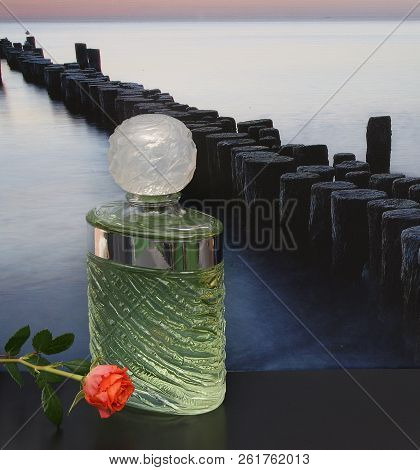 Fragrance For Ladies, Large Perfume Bottle In Front Of The Picture Of A Groyne In The Sea Decorated 