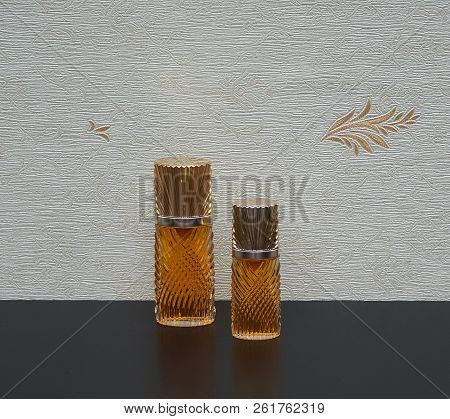 Fragrance For Ladies, Large Perfume Bottle Next To A Commercial Perfume Bottle In Front Of The Satin
