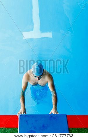 Photo of top athlete standing at edge of indoor pool