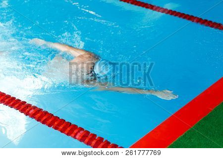 Photo of sportsman swimming in style of crawl in swimming pool