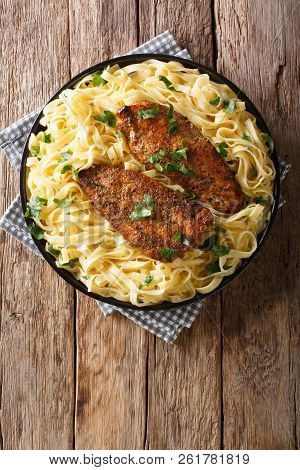 New Orleans Chicken Lazone Fried With Spices And Fettuccine Pasta In A Creamy Sauce Close-up. Vertic