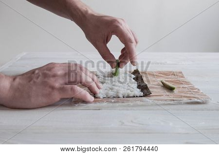 Process Of Making Maki Sushi. Cook Chef Hands Preparing Rolls With Cheese, Avocado And Sesame Seeds 