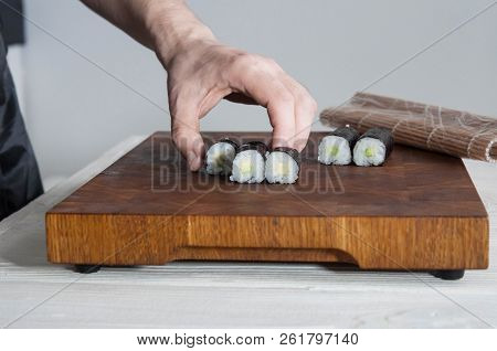 Process Of Making Maki Sushi. Cook Chef Hands Preparing Rolls With Cheese, Avocado And Sesame Seeds 