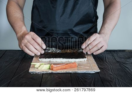 Process Of Making Maki Sushi. Cook Chef Hands Preparing Rolls With Cheese, Avocado And Sesame Seeds 