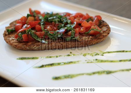 Bruschetta Toast With Tomatoes And Pesto On A Plate.