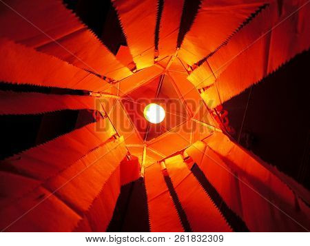 Vibrant Saffron Red Kandeel Lantern With Incandescent Lamp Inside Lantern Visible With Central Symme