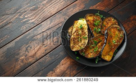 Healthy Vegeterain Oven Baked Aubergines, Eggplant With Parsley And Herbs In A Black Plate