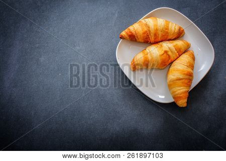 Delicious Croissants On A Square White Plate On Dark Craft Paper.