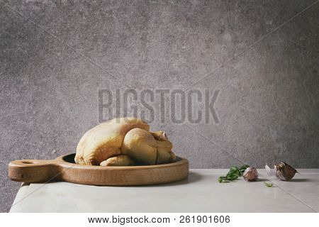 Raw Organic Uncooked Whole Yellow Corn Mini Chicken On Wooden Cutting Board With Basil Herbs And Gar