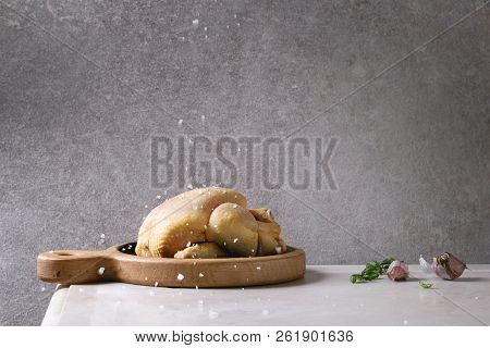 Raw Organic Uncooked Whole Yellow Corn Mini Chicken On Wooden Cutting Board With Sprinkling Salt, He