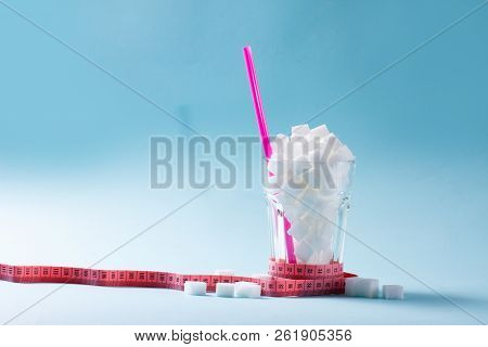 Sugar Cubes In Glass With Measuring Tape, Diabetes And Sugar Overuse Concept, Blue Background With C
