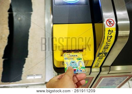 Osaka, Japan, May 19, 2018 : Closeup Hand Of People Insert Subway Ticket In The Entrance Automatic T