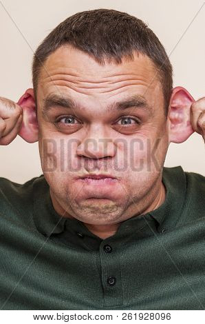 Human Face Can Be Different With Strong Expressions And Emotions. Man Pouting Mouth And Pulling Ears