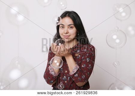 Beautiful Girl Among The Glass Balls One Of Which She Holds In Her Hands