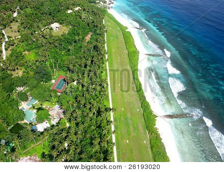 Nuova versione: un aerodromo di erba su un isola delle Seychelles, visto dall'aria, utilizzato per elicotteri e li