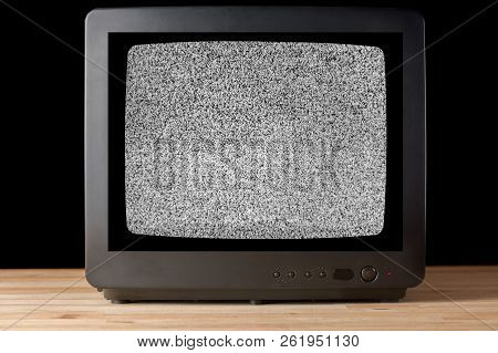 Old Vintage Tv Set Televisor On Wooden Table Againt Black Background With No Signal Television Grain