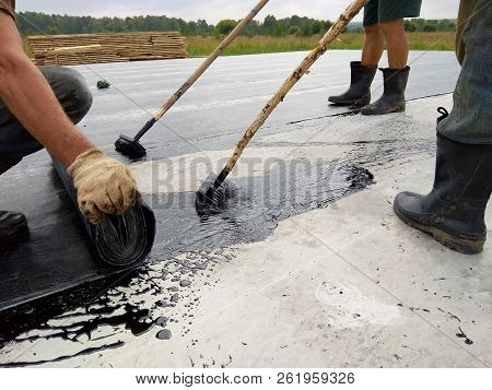 Roofer Worker Painting Bitumen Praimer At Concrete Surface By The Roller Brush Waterproofing
