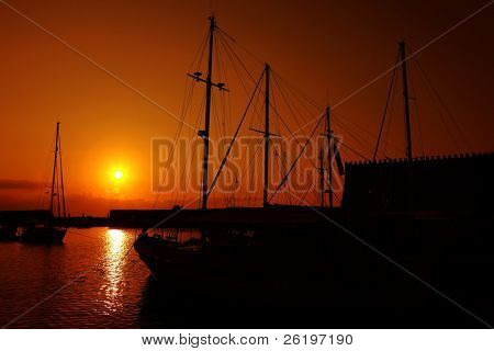 Indstillingen solen over Heraklion yacht harbour i kretensisk øens hovedstad, med den venetianske æra for