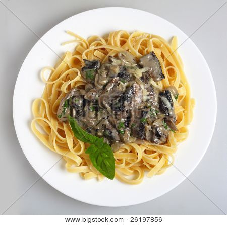 Un repas de fettuccini aux champignons, l'oignon et l'ail dans une sauce crème et le persil, servis avec un sp