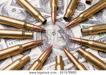 Concept Of Live Ammunition Is Aimed At A Portrait Of Benjamin Franklin On A Hundred Dollar Bill. The